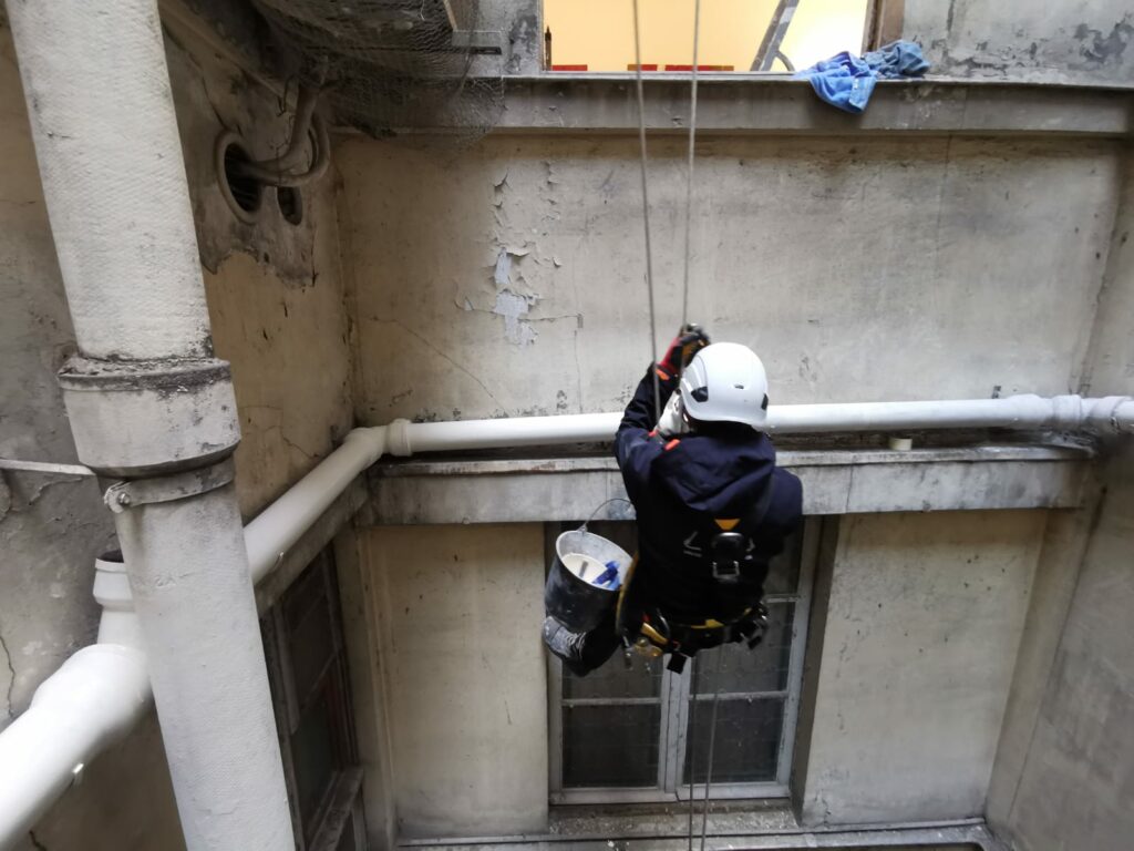 Un technicien cordiste en train de remonter sur corde.